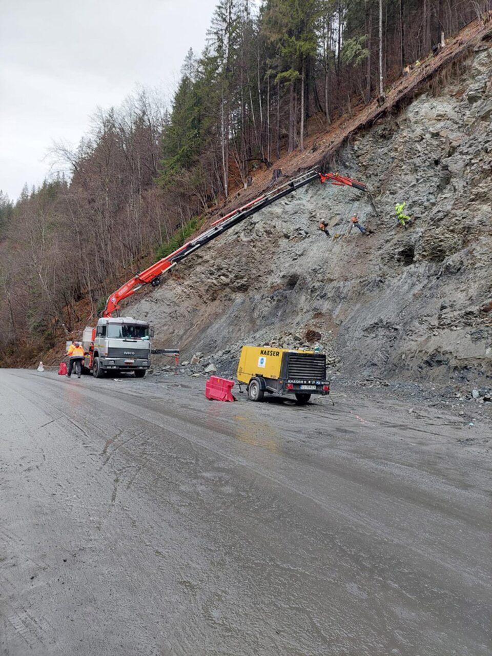 Alpiniști utilitari lucrează pentru prinderea unor plase de protecție