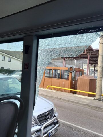 Geamurile unui autobuz TPL, sparte de un TIR care l-a „agățat” la un viraj