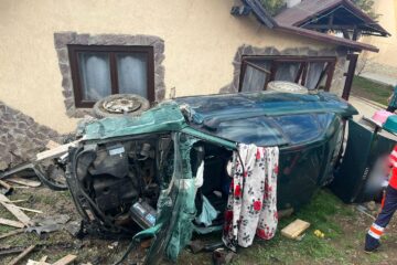 O persoană a rămas încarcerată după ce o mașină a rupt un gard și s-a răsturnat într-o curte