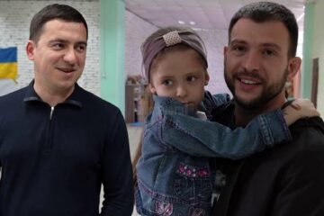Mihai și Dumitru împreună cu un copil refugiat