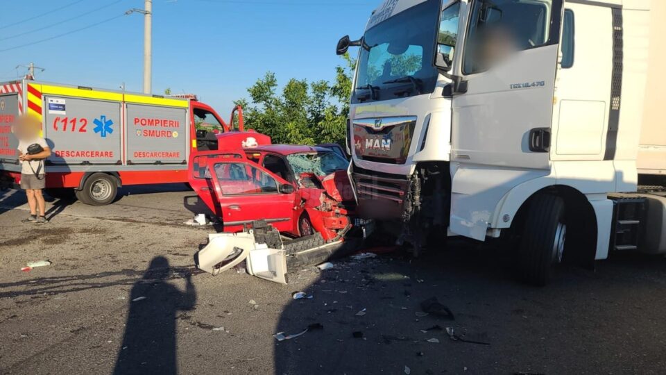 Femeie prinsă între fiarele contorsionate ale unei mașini lovite de un tir