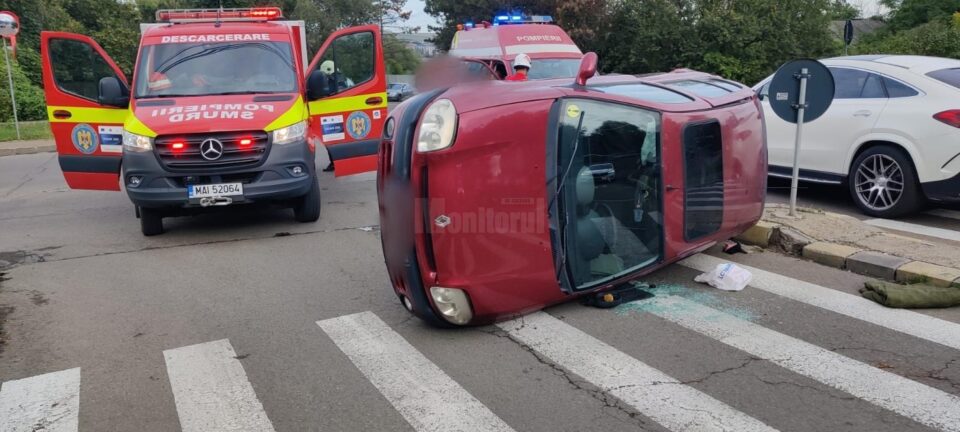 Mașina răsturnată în urma impactului