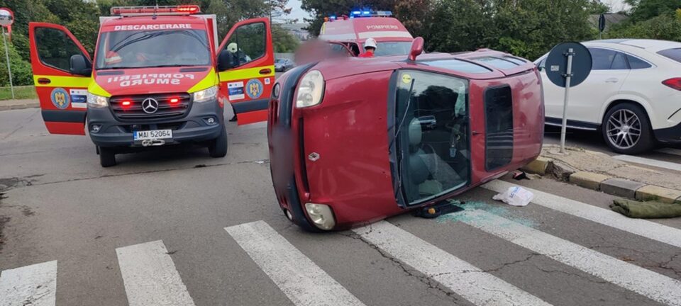 Mașina răsturnată în urma impactului