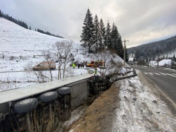Un șofer s-a răsturnat cu tirul în albia unui pârâu după ce a uitat să frâneze într-o curbă