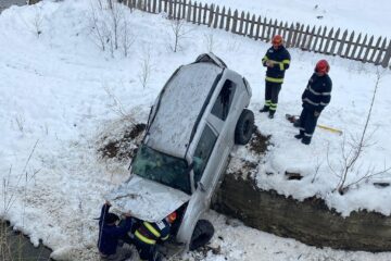 O mașină a ajuns în albia unui pârâu după ce a derapat pe șoseaua umedă