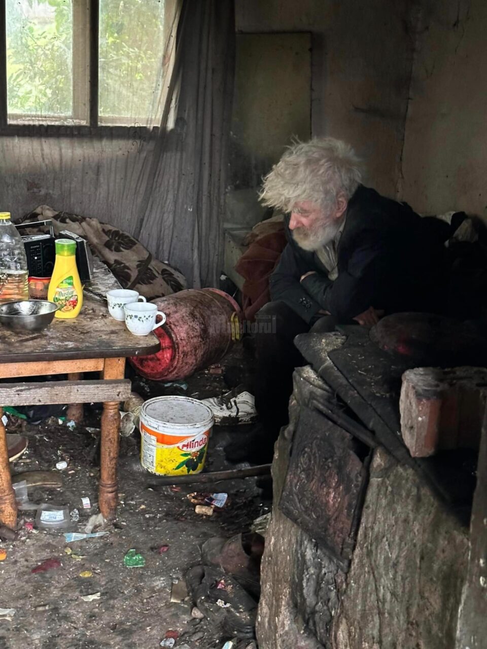 Bătrân găsit paralizat în casă, printre gunoaie