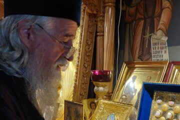 Părintele Diaconașu atinge cu evlavie una din raclele cu moaște