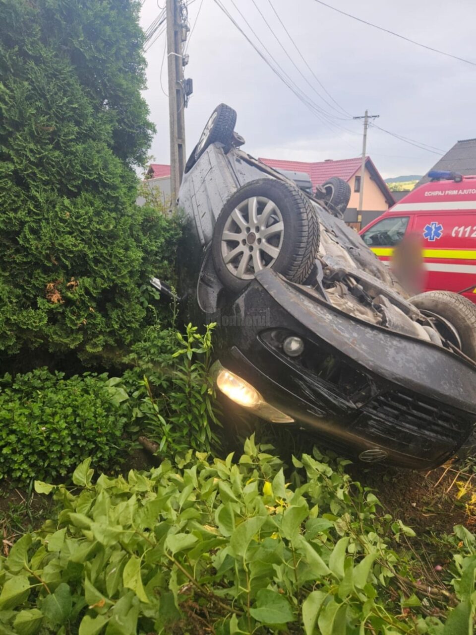 O șoferiță însărcinată s-a răsturnat cu mașina în curtea unei case