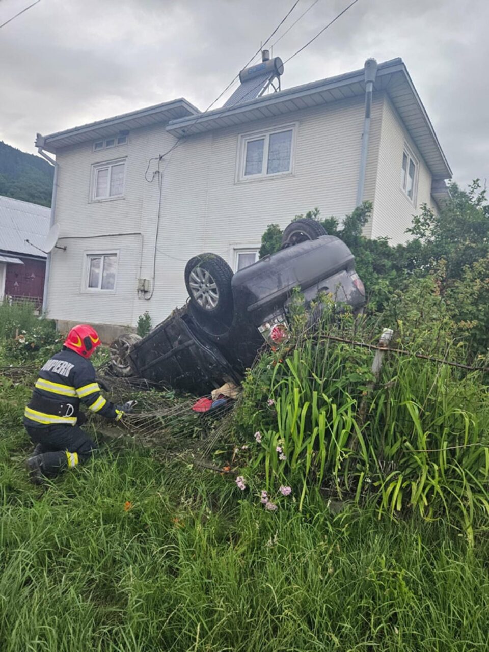 O șoferiță însărcinată s-a răsturnat cu mașina în curtea unei case