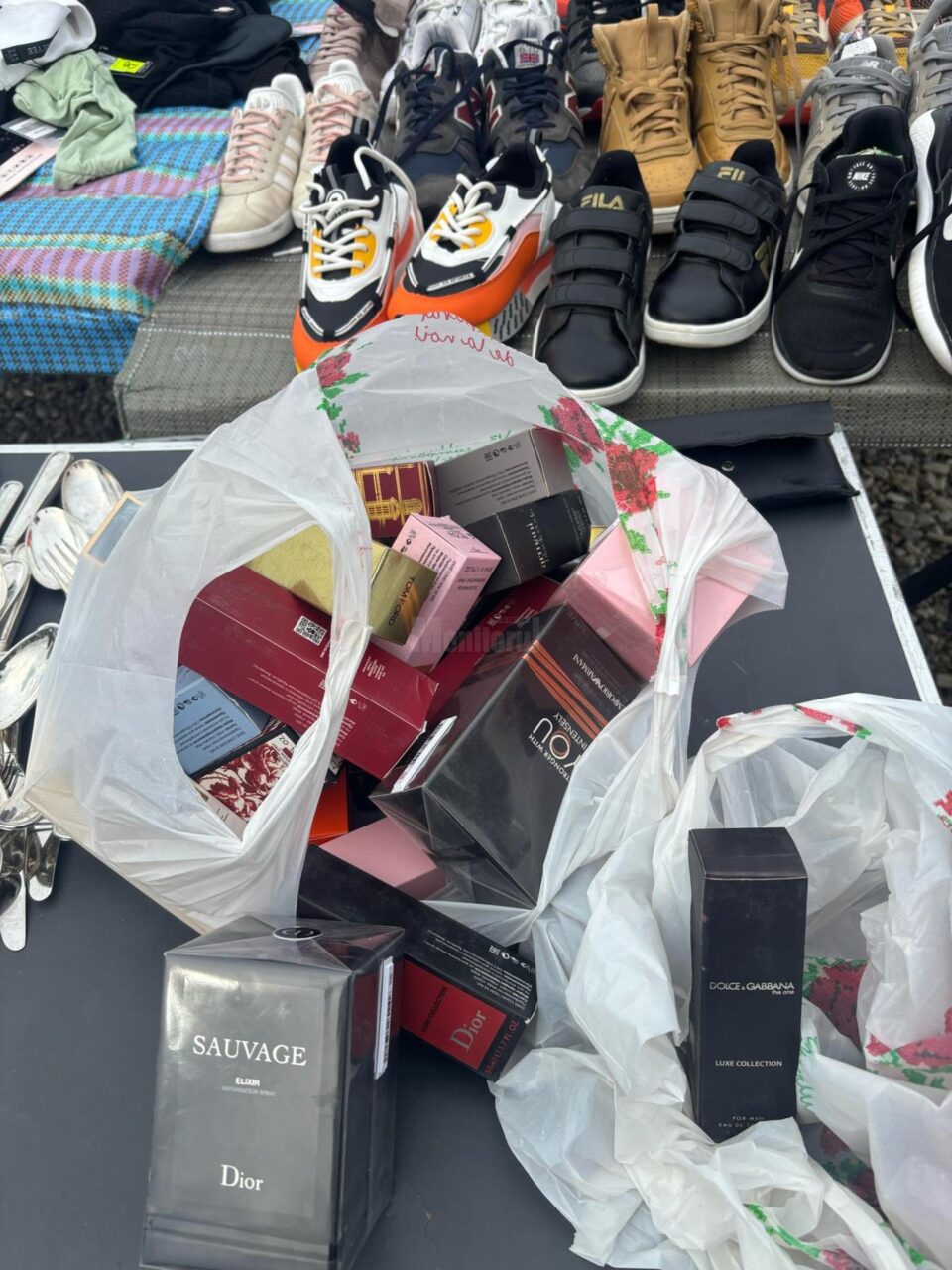 Zeci de haine și parfumuri contrafăcute, confiscate în urma unei acțiuni a polițiștilor