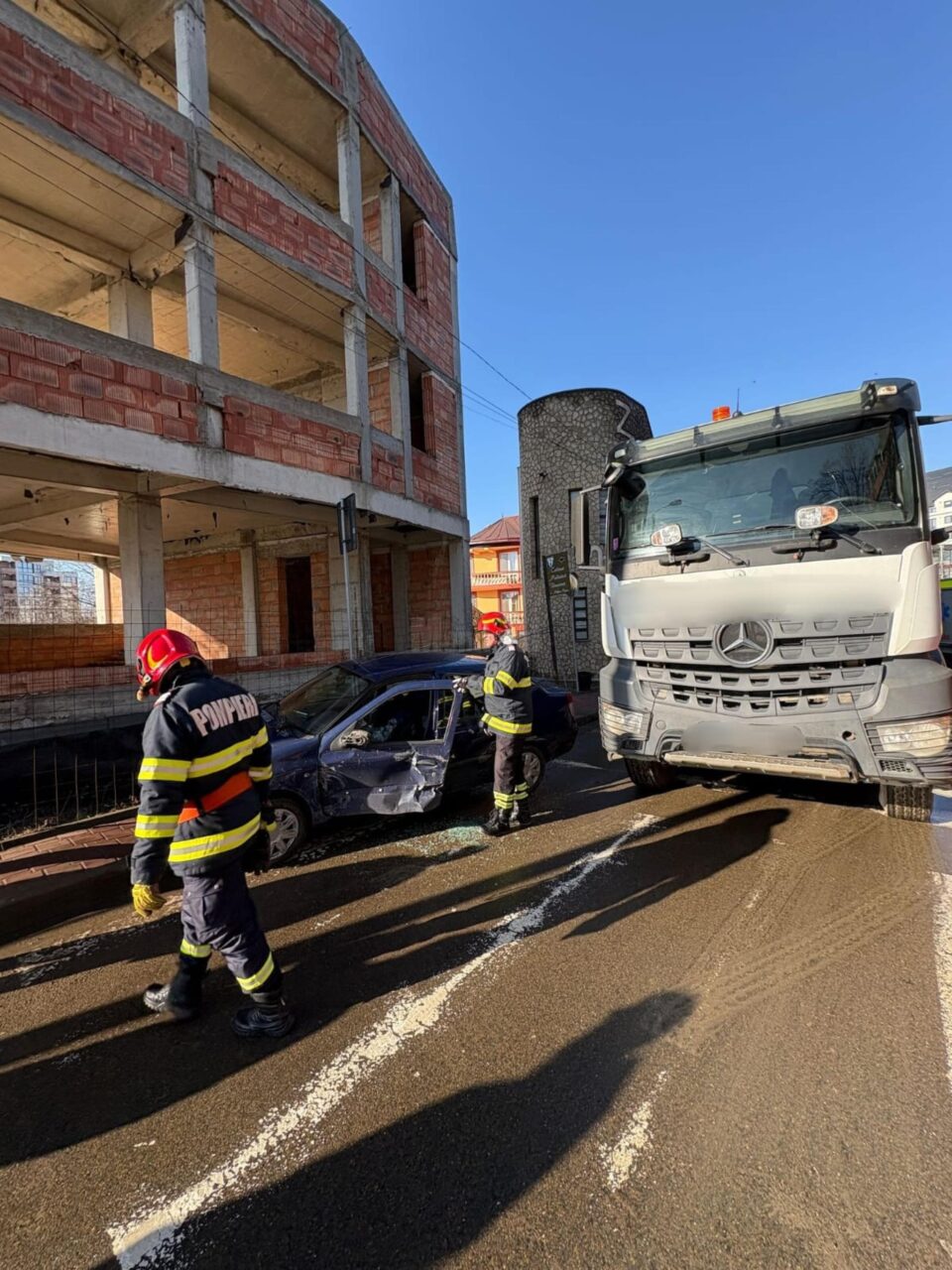Autoturism agățat de o autobenă, pe o stradă din Suceava