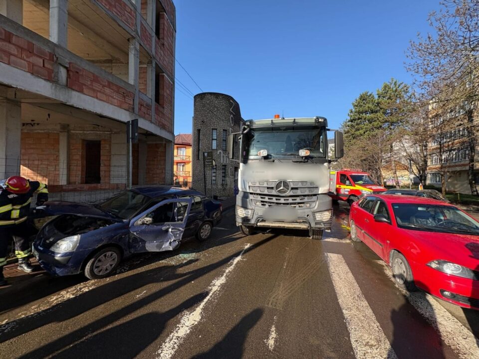 Autoturism agățat de o autobenă, pe o stradă din Suceava