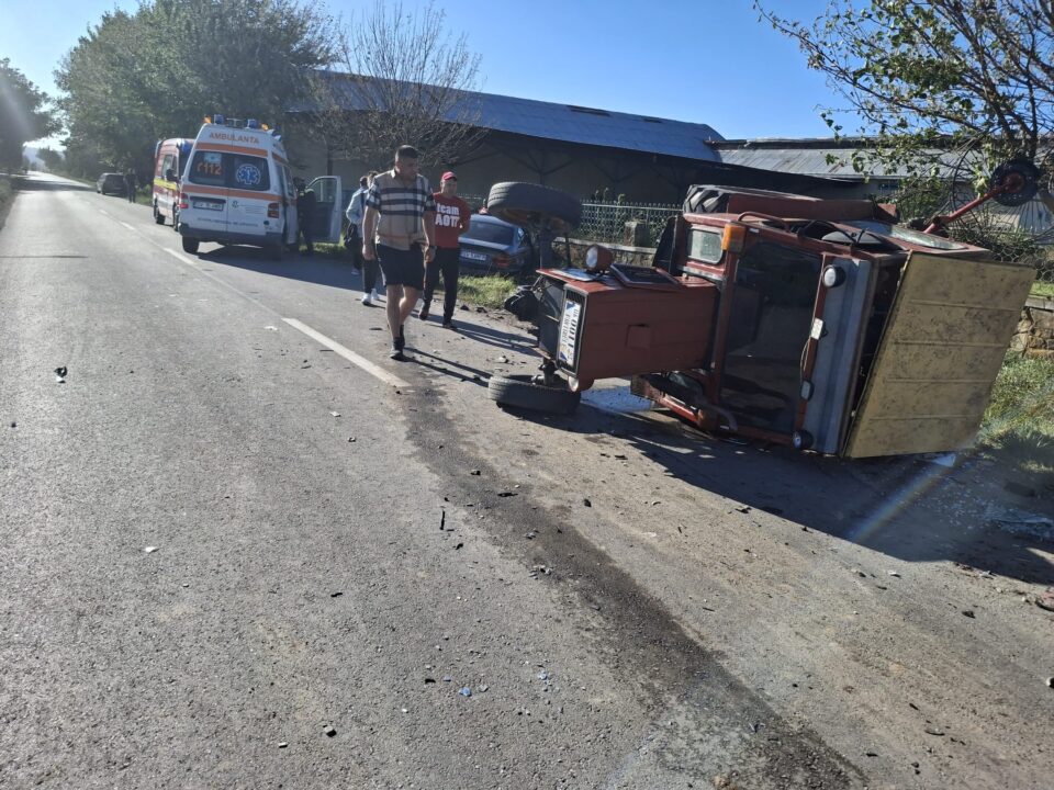 Tractor răsturnat de un BMW, care după impact s-a oprit într-un gard