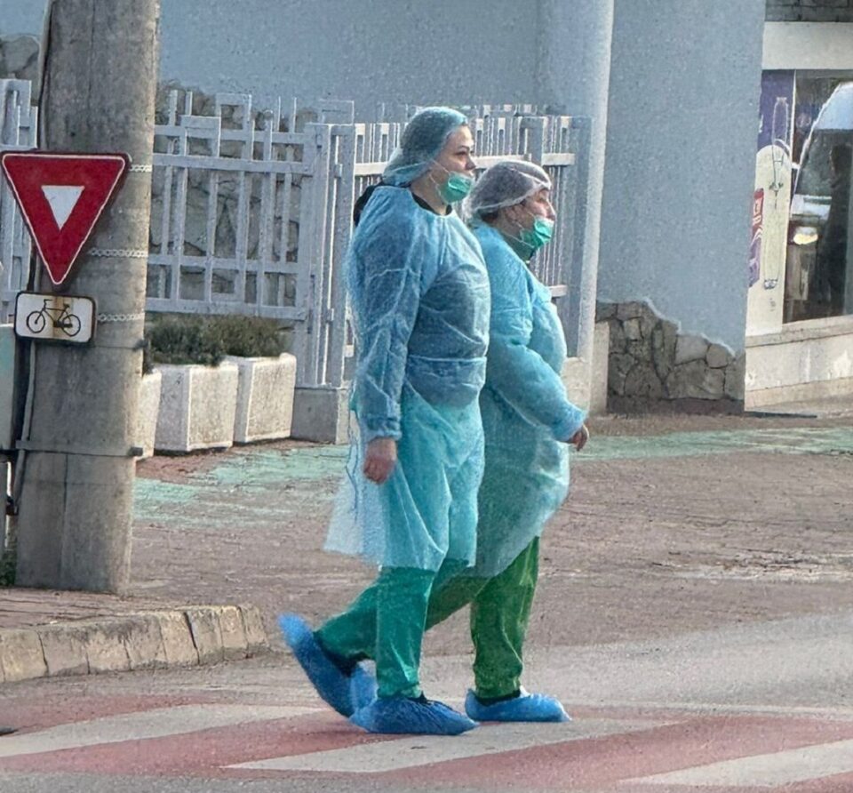 Emanuel Ungureanu a prezentat o fotografie cu doi angajați ai Spitalului Județean care traversează o trecere de pietoni îmbrăcați în echipament medical