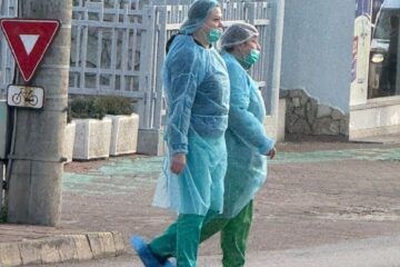 Emanuel Ungureanu a prezentat o fotografie cu doi angajați ai Spitalului Județean care traversează o trecere de pietoni îmbrăcați în echipament medical