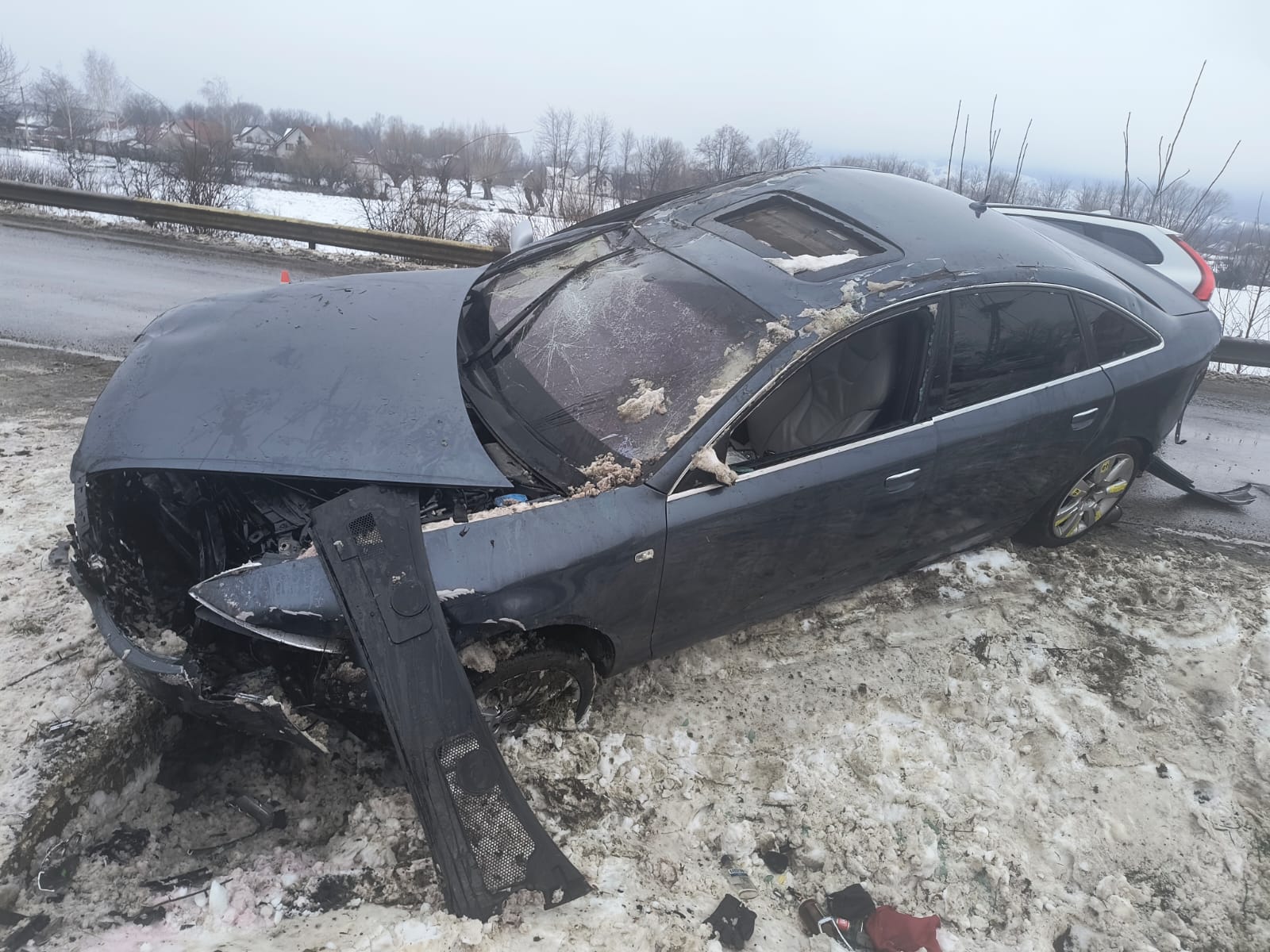 Doi tineri băuți și recalcitranți, încătușați lângă un Audi cu care intraseră într-un gard și într-un stâlp