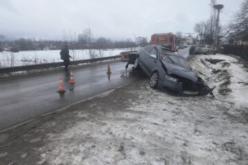 Doi tineri băuți și recalcitranți, încătușați lângă un Audi cu care intraseră într-un gard și într-un stâlp