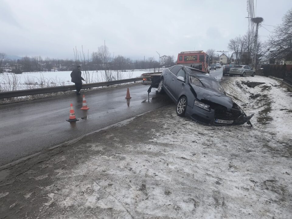 Doi tineri băuți și recalcitranți, încătușați lângă un Audi cu care intraseră într-un gard și într-un stâlp