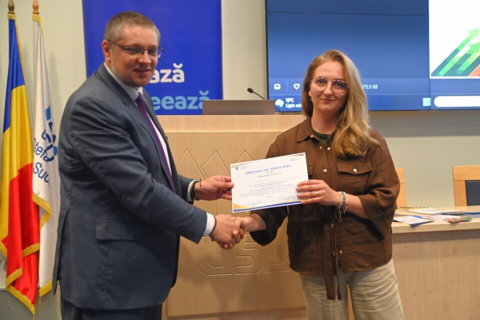 Conf.univ.dr. Ghiuta Ovidiu si administrator Eco Optic, Ruxandra Mihalachi, care primește diploma de apreciere